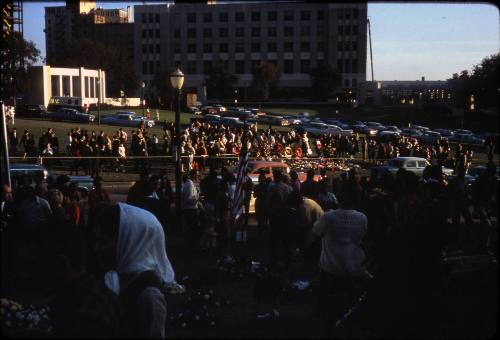 Image of mourners and memorial flowers in Dealey Plaza after the assassination