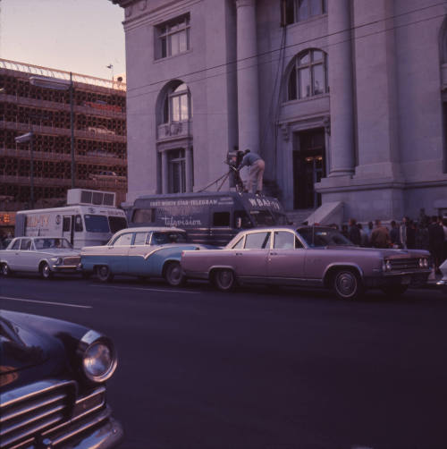 Color image of press outside Dallas City Hall after the assassination