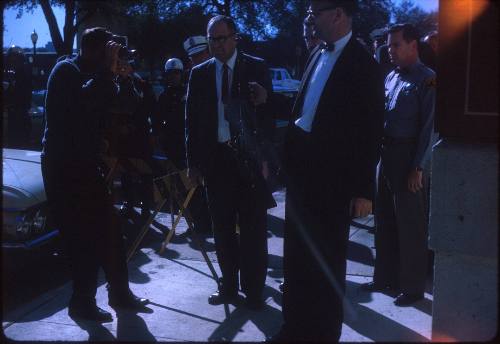 Image of Lt. J. C. "Carl" Day holding rifle outside the Book Depository